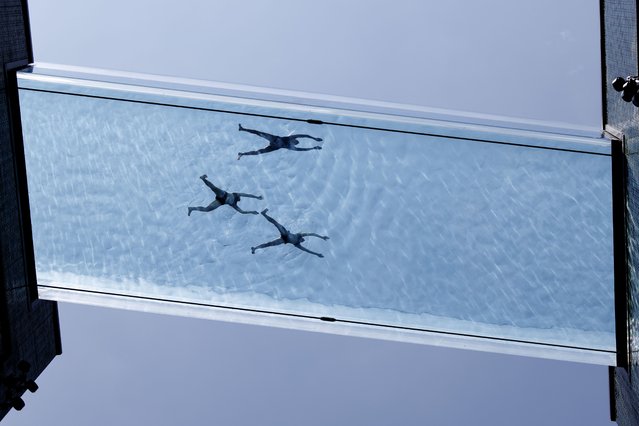 People swim in the Sky Pool, which is a 25-meter long swimming pool, suspended 35 meters above the ground that acts as a bridge between two residential buildings at Embassy Gardens in London, Britain, 13 June 2025. The first yellow heat-health alert of 2025 has been issued for London and other regions of Britain by the UK Health Security Agency (UKHSA) as temperatures are expected to rise up to 30 degrees Celsius. (Photo by Tolga Akmen/EPA)