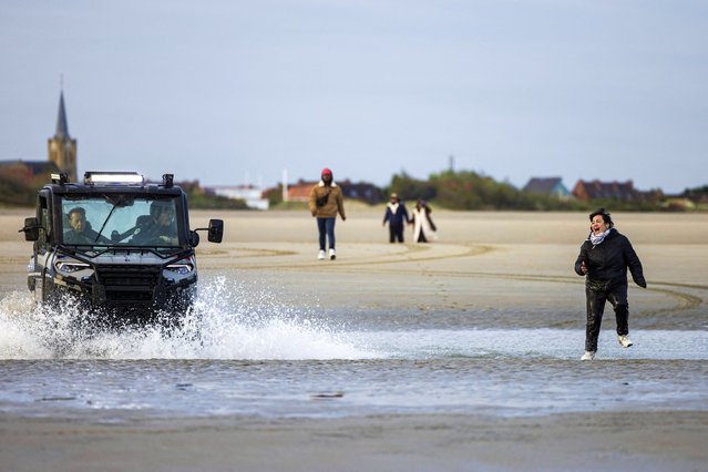 A migrant reacts as she is chased by French police while attempting to board a smuggler's boat in an attempt to cross the English Channel, on the beach of Gravelines, near Dunkirk, northern France on April 26, 2024. Five migrants, including a seven-year-old girl, died on April 23, 2024 trying to cross the Channel from France to Britain, local authorities said, just hours after Britain passed a controversial bill to deport asylum seekers to Rwanda. (Photo by Sameer Al-Doumy/AFP Photo)