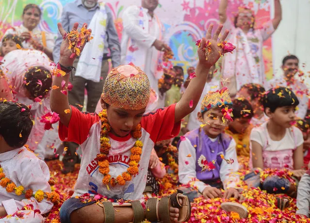 Indian children play with flower petals at an event to celebrate the Hindu festival of Holi for children with cerebral palsy organized by the Trishla Foundation in Allahabad on February 25, 2018. (Photo by Sanjay Kanojia/AFP Photo)