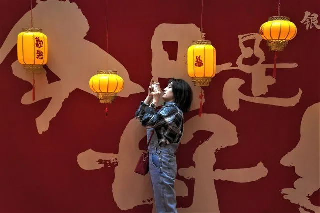 A woman takes a picture of a lantern display inside a shopping mall in Beijing, Sunday, February 5, 2023. The Lantern Festival, the end of the Lunar New Year holiday period, falls on Sunday. (Photo by Andy Wong/AP Photo)