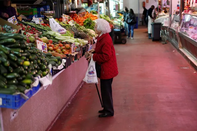A woman looks at fruits and vegetables at a market stall in Madrid January 29, 2013. (Photo by Juan Medina/Reuters)
