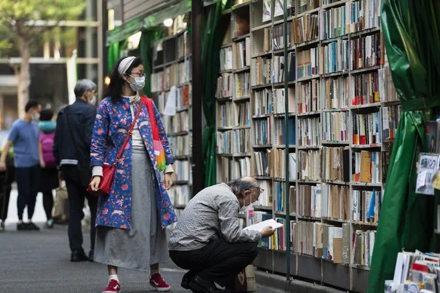 People wearing face masks shop around at a secondhand book store in Tokyo on Thursday, October 29, 2020. (Photo by Hiro Komae/AP Photo)