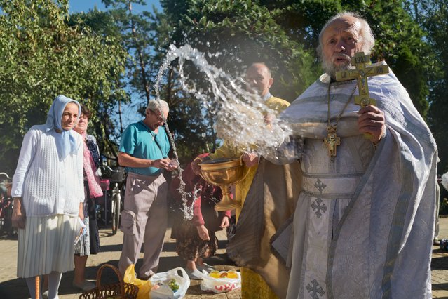 Residents attend church, where an Orthodox priest sprinkles holy water over them and their baskets of fruits and honey during Apple Savior (Feast of the Transfiguration), a traditional Christian orthodox holiday when fruits and honey are shared among families and the community on August 19, 2025 in Sloviansk, Ukraine. Sloviansk, where the Donbas war began in 2014 remains a strategic flashpoint in the Donetsk region amid Russia's ongoing invasion. The Donetsk Oblast has been mentioned in the peace-talk discussions involving U.S. President Donald Trump and Russian President Vladimir Putin regarding a potential frontline freeze and territorial exchanges. (Photo by Pierre Crom/Getty Images)