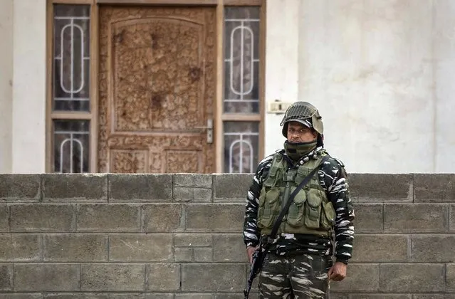 An Indian paramilitary soldier stands guard as National Investigation Agency personnel search the premises of Agence France-Presse’s Kashmir correspondent Parvaiz Bukhari on the outskirts of Srinagar, Indian controlled Kashmir, Wednesday, October 28, 2020. (Photo by Mukhtar Khan/AP Photo)