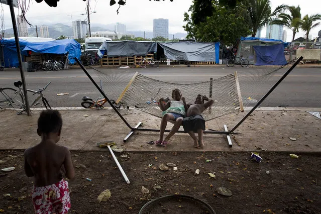 In this Tuesday, August 25, 2015 photo, two children rest on a hammock at a homeless encampment in the Kakaako district of Honolulu. (Photo by Jae C. Hong/AP Photo)