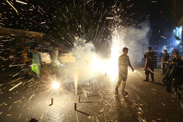 A person lights fire crackers during the celebrations of Mawlid al-Nabi, the birth anniversary of Prophet Muhammad, in Hyderabad, Pakistan, 04 September 2025. Mawlid is observed on the 12th day of Rabi al-Awwal (the third month of the Islamic calendar) in Sunni Islam and on the 17th day in Shiite Islam. (Photo by Nadeem Khawar/EPA)