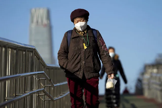 Women wearing face masks to help curb the spread of the coronavirus walk along a pedestrian bridge in Beijing, Monday, November 30, 2020. (Photo by Andy Wong/AP Photo)