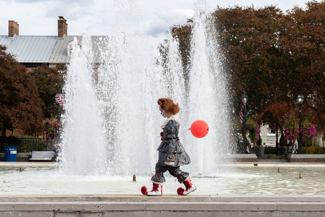 A child dressed as Pennywise, the clown from Stephen King's “It”, walks around a fountain during a Halloween trick-or-treat event in Old Town Alexandria, Virginia on October 25, 2025. (Photo by Kylie Cooper/Reuters)