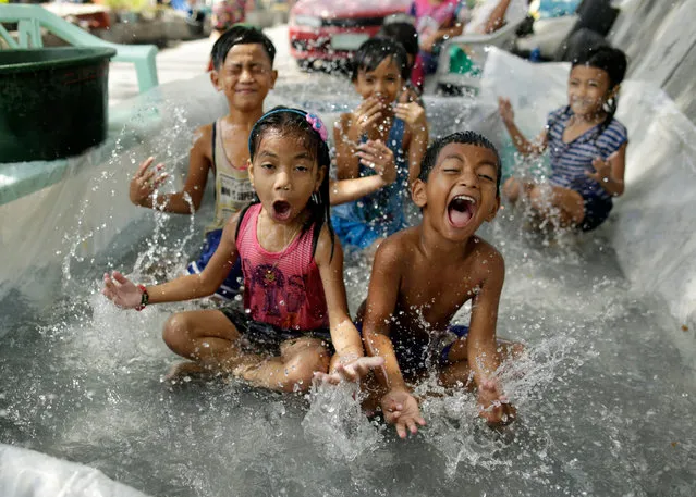 Filipino children play in a makeshift pool on the street side in Manila, Philippines, 10 April 2018. The state weather bureau issued public warnings as temperatures start to climb. (Photo by Francis R. Malasig/EPA/EFE)
