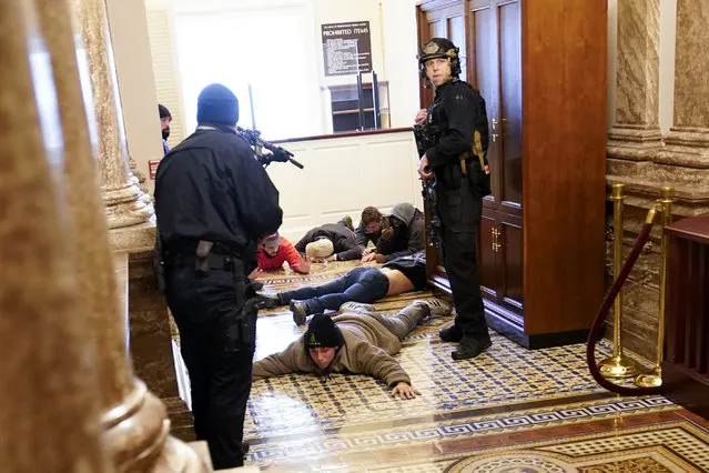 U.S. Capitol Police hold protesters at gun-point near the House Chamber inside the U.S. Capitol on Wednesday, January 6, 2021, in Washington. (Photo by Andrew Harnik/AP Photo)