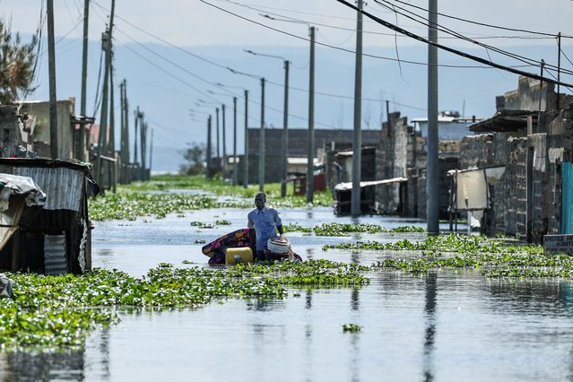 A man evacuates his belongings within a flooded residential area as people continue to vacate from their flooded homes affected by floods and raising backflow waters from Lake Naivasha which has been worsened by prolonged rainfall in Kihoto Esatate, in the Lakeview award, in Naivasha, about 90km northwest of Nairobi, in the rift valley, Kenya, on 11 November 2025. Thousands of residents of Kihoto Etate, in Naivasha, Nakuru County, have been affected by floods caused by the rising waters of Lake Naivasha. Water levels has been rising to unprecedented levels that has been expanding the lake since 2020, among other lakes in the Rift Valley that have been steadily rising. (Photo by Daniel Irungu/EPA)