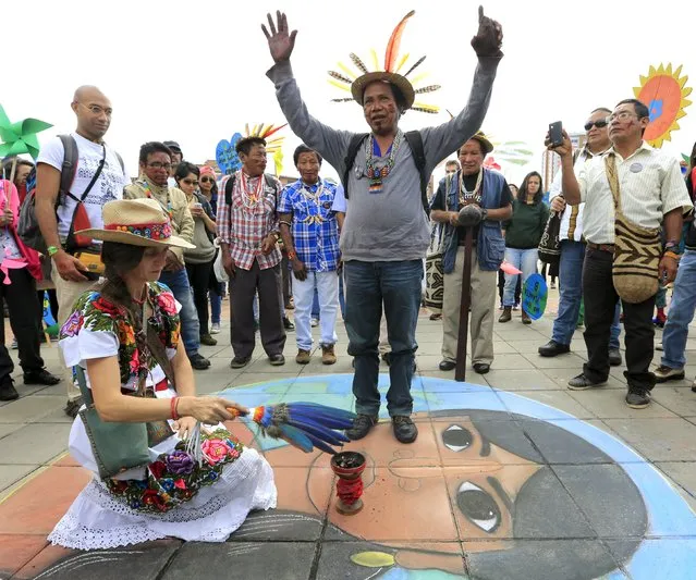 A Colombian Barzano man and a woman take part in a symbolic ritual before a march ahead of the 2015 Paris Climate Change Conference (COP21), in Bogota, Colombia November 29, 2015. (Photo by Jose Miguel Gomez/Reuters)