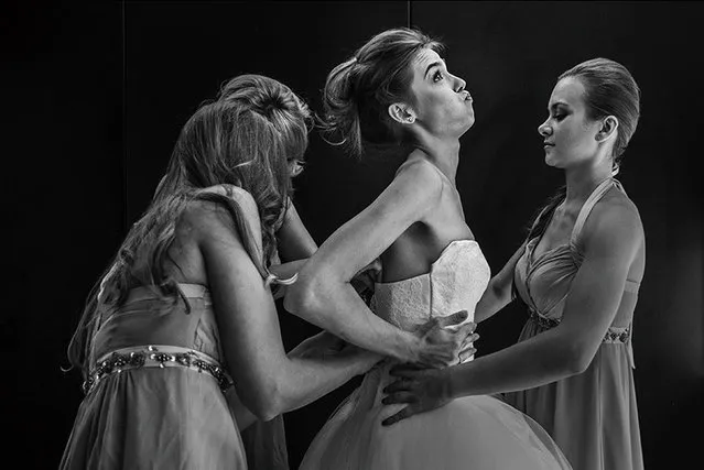 The Bride getting into her dress wiht her Bridesmaids. Bristol, UK. (Photo by Rich Howman/Caters News)