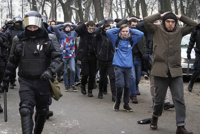 Detained protesters walk escorted by police during a protest against the jailing of opposition leader Alexei Navalny in St. Petersburg, Russia, Sunday, January 31, 2021. (Photo by Dmitri Lovetsky/AP Photo)