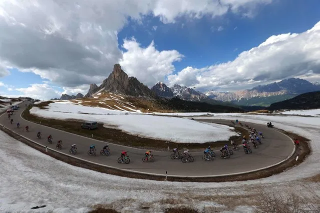 The pack of riders cycles down the Passo Giau pass in the Dolomites mountains during the nineteenth stage of the Giro d'Italia 2023 cycling race, 183 km between Longarone and Tre Cime di Lavaredo (rifugio Auronzo) on May 26, 2023.  (Photo by Luca Bettini/AFP Photo)