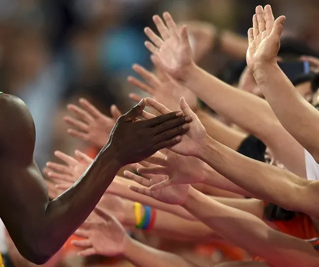 Usain Bolt of Jamaica shakes hands with fans after winning the men's 200 metres final during the 15th IAAF World Championships at the National Stadium in Beijing, China, August 27, 2015. (Photo by Dylan Martinez/Reuters)