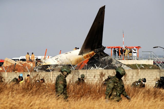 South Korean soldiers check near the wreckage of a passenger plane at Muan International Airport on December 29, 2024 in Muan-gun, South Korea. A plane carrying 181 people, Jeju Air Flight 7C2216, crashed at Muan International Airport in South Korea after skidding off the runway and colliding with a wall, resulting in an explosion. Early reports said that at least 120 people had died. (Photo by Chung Sung-Jun/Getty Images)
