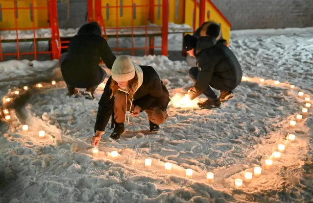 Supporters of Russian opposition politician Alexei Navalny, who was recently jailed for parole violations, arrange candles in the shape of a heart in a residential courtyard during a gathering on Valentine's Day in Omsk, Russia on February 14, 2021. (Photo by Alexey Malgavko/Reuters)
