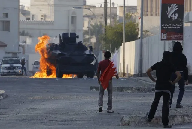 A riot police armoured personnel carrier is seen engulfed with fire from a molotov cocktail thrown by protesters during clashes in the village of Bilad Al Qadeem south of Manama, February 5, 2015. Protesters clashed with riot police demanding for the release of Bahraini opposition leader Sheik Ali Salman. (Photo by Hamad I. Mohammed/Reuters)