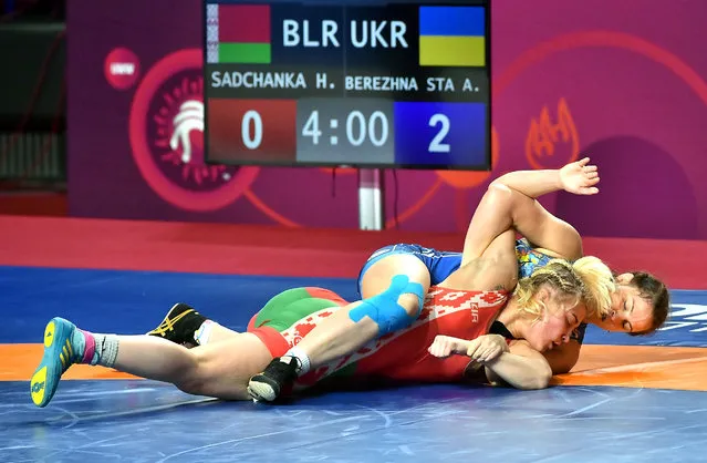 Hanna Sadchanka (red) of Belarus in action against Alina Berezhna Stadnik Makhynia (blue) of Ukraine in their women's -68kg category bout at the European Wrestling Championships in Warsaw, Poland, 22 April 2021. (Photo by Andrzej Lange/EPA/EFE)