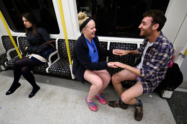 Participants in the annual International "No Pants Subway Ride" travel on a London underground train in London, on January 10, 2016. Started in 2002 with only seven participants, the day is now marked in over 60 cities around the world. The idea behind "No Pants" is that random passengers board a subway car at separate stops in the middle of winter, without wearing trousers. (Photo by Leon Neal/AFP Photo)