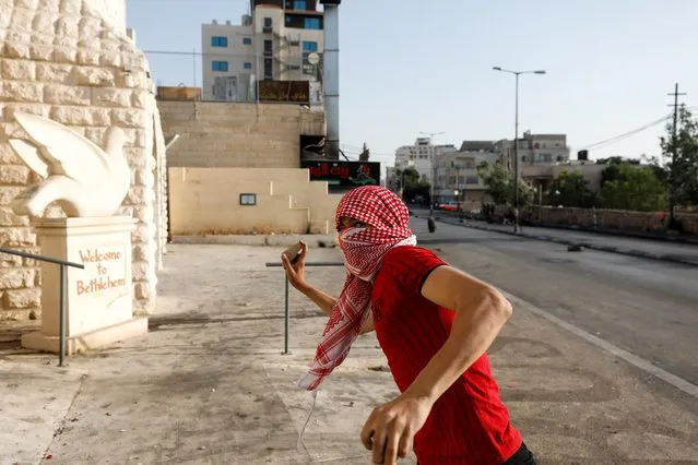 A Palestinian demonstrator aims to hurl a stone at Israeli forces during an anti-Israel protest, in Bethlehem in the Israeli-occupied West Bank on May 20, 2021. (Photo by Mussa Qawasma/Reuters)