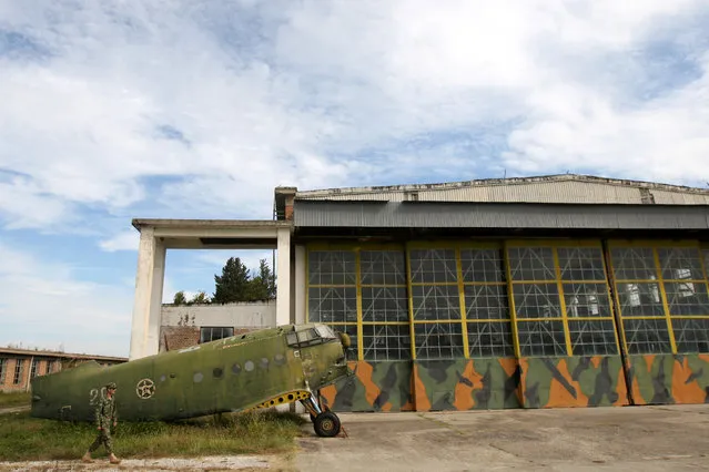 An Albanian Air Force member walks near an old non-function Airplane (Antonov An-2) in Kucova Air Base in Kucova, Albania on October 3, 2018. Albania retired its 224 Soviet- and Chinese-made MiGs in 2005, and since 2009 NATO neighbors Italy and Greece monitor its airspace. That led to economic decline in and around Kucova, which was called "Stalin City" during the era of Communist rule. (Photo by Florion Goga/Reuters)