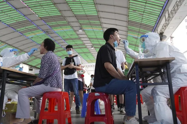 Residents get tested for the coronavirus in a district in Guangzhou in southern China's Guangdong province on Sunday, May 30, 2021. The southern Chinese city of Guangzhou shut down a neighborhood and ordered residents to stay home Saturday to be tested for the coronavirus following an upsurge in infections that has rattled authorities. (Photo by AP Photo/Stringer)