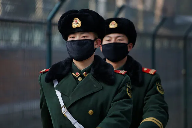 Paramilitary policemen wearing masks march in front of an embassy in central Beijing, China as a red alert is issued for air pollution in the capital December 18, 2016. (Photo by Damir Sagolj/Reuters)