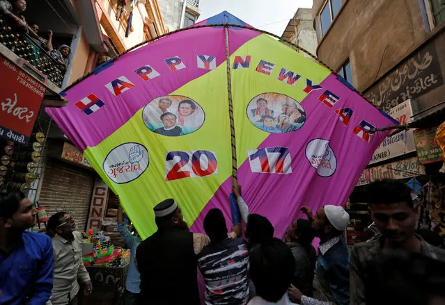 People fix a giant kite decorated with images of politicians to welcome the new year at a kite market in Ahmedabad, India, December 31, 2016. (Photo by Amit Dave/Reuters)