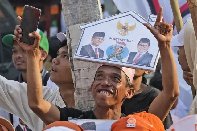 A supporter of presidential candidate Anies Baswedan and his running mate Muhaimin Iskandar cheers as he waits for the pair's arrival to register their names to run in next year's election at the General Election Commission building in Jakarta, Indonesia, Thursday, October 19, 2023. (Photo by Achmad Ibrahim/AP Photo)