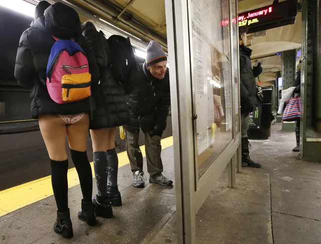 A man studies the map as two pantless women wait for their train along the R line during the annual 16th annual No Pants Subway Ride, Sunday, January 8, 2017, in the Brooklyn borough of New York. (Photo by Kathy Willens/AP Photo)