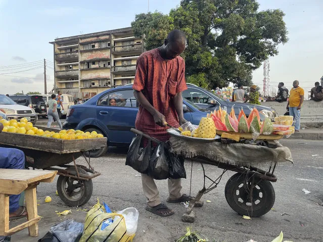 A man sells fruits on the street in Lagos, Nigeria Wednesday, November 29, 2023. Nigeria's leader on Wednesday presented a $34 billion spending plan for 2024 to federal lawmakers with a key focus on stabilizing Africa's largest but ailing economy and fighting the nation's deadly security crisis. (Photo by Sunday Alamba/AP Photo)