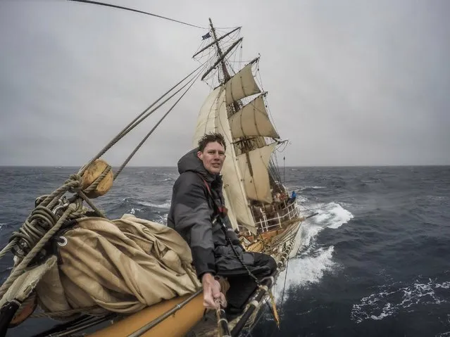 Traveller Andy perches on the bow of the ship as it navigates the rocky waters, on March 31, 2015 in the Atlantic Ocean. (Photo by Andrew Orr/Barcroft Images)