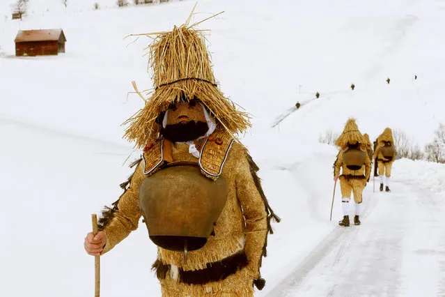 Men dressed as “Chlaeuse”, figures that scare away evil spirits, carry round bells and cowbells as they walk on a partially snow-covered road during the traditional “Sylvesterchlausen” near the northeastern village of Urnaesch, Switzerland January 13, 2017. (Photo by Arnd Wiegmann/Reuters)