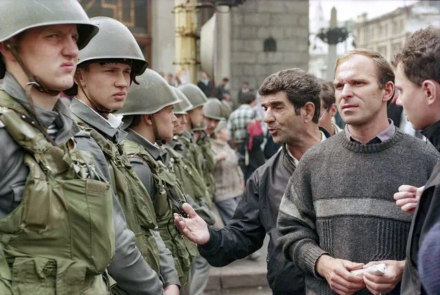 In this Tuesday, August 20, 1991 file photo, Muscovites debate with soldiers who guard the Manezh Square at Gorky Street in downtown Moscow during the coup attempt by hard-line Communists against the Soviet president, Russia. (Photo by Boris Yurchenko/AP Photo/File)