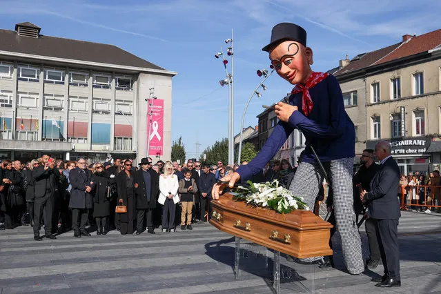 Illustration shows Decrocher la lune main character, Sancho, touch the coffin, with the family and relatives around at the funeral ceremony for Franco Dragone, Italian-Belgian theater director and founder and artistic director of Dragone on Tuesday, October 11, 2022 in La Louviere, Belgium. Dragone passed away on 30 September at the age of 69 after suffering a hearth attack. (Photo by Rex Features/Shutterstock)