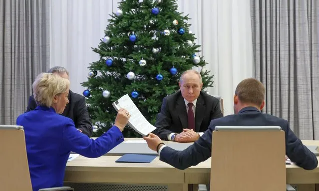 In this pool photograph distributed by Russia's state agency Sputnik, Russian President Vladimir Putin submits his documents to be registered as a presidential candidate at the Central Election Commission in Moscow on December 18, 2023. The 2024 presidential election will be held over a three-day period from March 15 to 17. (Photo by Mikhail Klimentyev/Pool via AFP Photo)