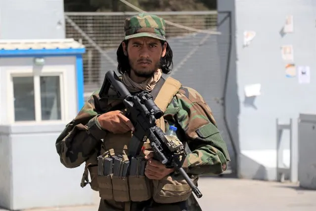 A Taliban soldier stands guard at the gate of Hamid Karzai International Airport in Kabul, Afghanistan, Sunday, September 5, 2021. Some domestic flights have resumed at Kabul's airport, with the state-run Ariana Afghan Airlines operating flights to three provinces. (Photo by Wali Sabawoon/AP Photo)