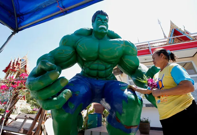 A Thai puts donation money into a statue depicting Hulk, a US fictional superhero character, at Wat Tam Ru temple in Samut Prakan province, on the outskirts of Bangkok, Thailand, 26 February 2016. The Buddhist abbot decorated the temple with statues of US superheroes as Iron Man, Hulk, Superman as well as Japanese manga series character Arale Norimaki to inspire and attract children and young people to visit the temple to learn about Buddhist teaching. (Photo by Rungroj Yongrit/EPA)