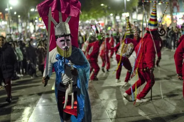 Dancers from Elotepec, in Veracruz state, perform as they arrive to the Basilica of Guadalupe in Mexico City, early Monday, December 12, 2022. Devotees of the Virgin of Guadalupe make the pilgrimage for her Dec. 12 feast day, the anniversary of one of several apparitions of the Virgin Mary witnessed by an Indigenous Mexican man named Juan Diego in 1531. (Photo by Aurea Del Rosario/AP Photo)