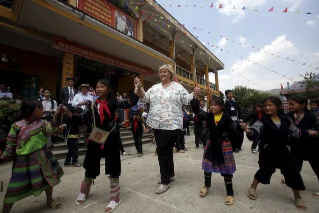 Norway's Prime Minister Erna Solberg (C) dances with Hmong pupils at Lao Chai primary school as she visits ethnic Hmong communities in Vietnam's northern Sapa district April 18, 2015. (Photo by Reuters/Kham)