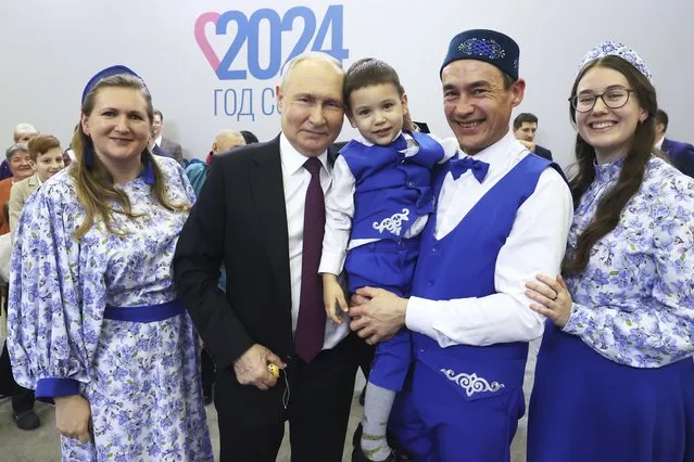 Russian President Vladimir Putin, center,  poses for a photo with participants of the Russian Family Forum “Relatives and Loved Ones” at the Russia Expo international exhibition and forum at the VDNKh (The Exhibition of Achievements of National Economy) in Moscow, Russia, Tuesday, January 23, 2024. (Photo by Sergei Karpukhin, Sputnik, Kremlin Pool Photo via AP Photo)