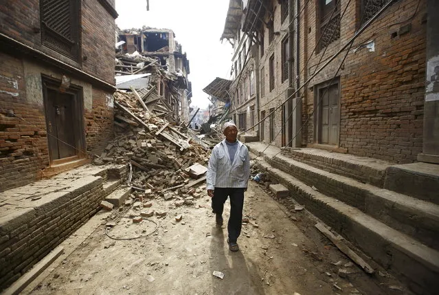 A man walks along damaged houses a day after an earthquake in Bhaktapur, Nepal April 26, 2015. (Photo by Navesh Chitrakar/Reuters)