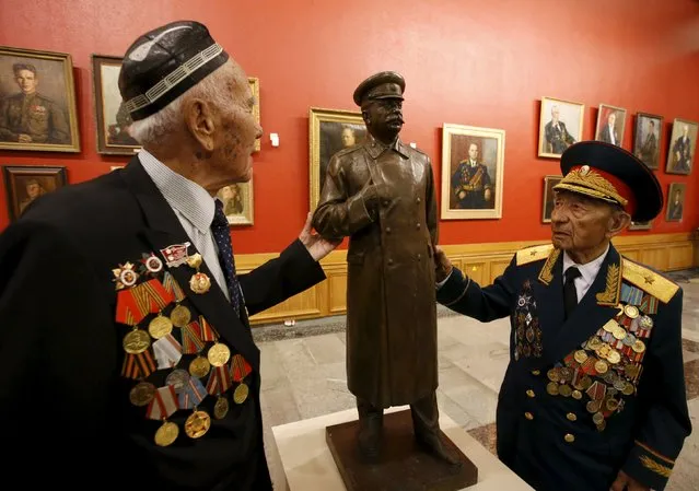 World War Two veterans touch an exhibit showing Soviet leader Joseph Stalin at the Central Museum of the Great Patriotic War at the Poklonnaya Gora War Memorial Park in Moscow, Russia, April 28, 2015. Russia will celebrate the 70th anniversary of the victory over Nazi Germany in World War Two in May. (Photo by Sergei Karpukhin/Reuters)