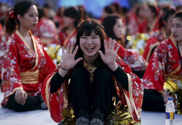 A Japanese participant reacts to the camera as she waits to perform a dance with others during the last day of World Culture Festival on the banks of the river Yamuna in New Delhi, India, March 13, 2016. (Photo by Adnan Abidi/Reuters)