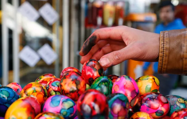 An Iranian seller adjusts colorful eggs displayed for sale as part of the traditions of the New Persian Year, called Nowruz, in Tehran, Iran, March 18, 2016. Buying goldfish and flowers is one of the New Year traditions for Iranians to celebrate Nowruz. The Persian New Year, starting on 20 March, also marks the beginning of spring. The Persian New Year which has been celebrated for at least 3,000 years is the most revered celebration in the greater Persian world, which includes the countries of Iran, Afghanistan, Azerbaijan, Turkey, and portions of western China and northern Iraq. (Photo by Abedin Taherkenareh/EPA)
