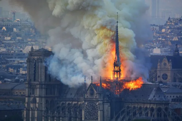 Smoke and flames rise during a fire at the landmark Notre-Dame Cathedral in central Paris on April 15, 2019, potentially involving renovation works being carried out at the site, the fire service said.  (Photo by Hubert Hitier/AFP Photo)