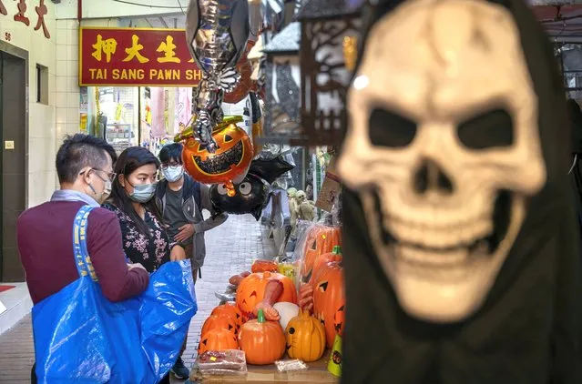 Customers are seen browsing for Halloween pumpkin ornaments at a stall days before Halloween in Hong Kong on October 25, 2021. (Photo by Miguel Candela/Anadolu Agency via Getty Images)