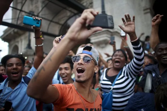 People react as they wait for an eventual visit of U.S. President Barack Obama to downtown Havana, March 21, 2016. (Photo by Alexandre Meneghini/Reuters)